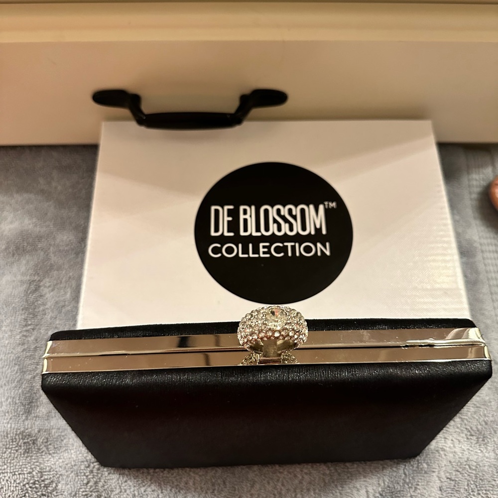 Small fancy clutch purse with rhinestone finger hole. It does not have a strap.